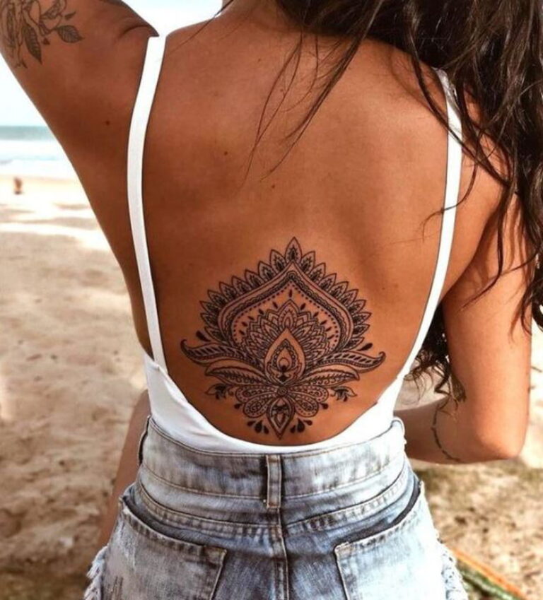 Tatouage mandala détaillé dans le dos d'une femme, représentant un style féminin et élégant.