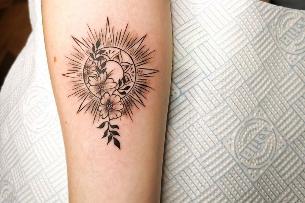 Tatouage soleil somptueux représentant harmonie et lumière sur un bras