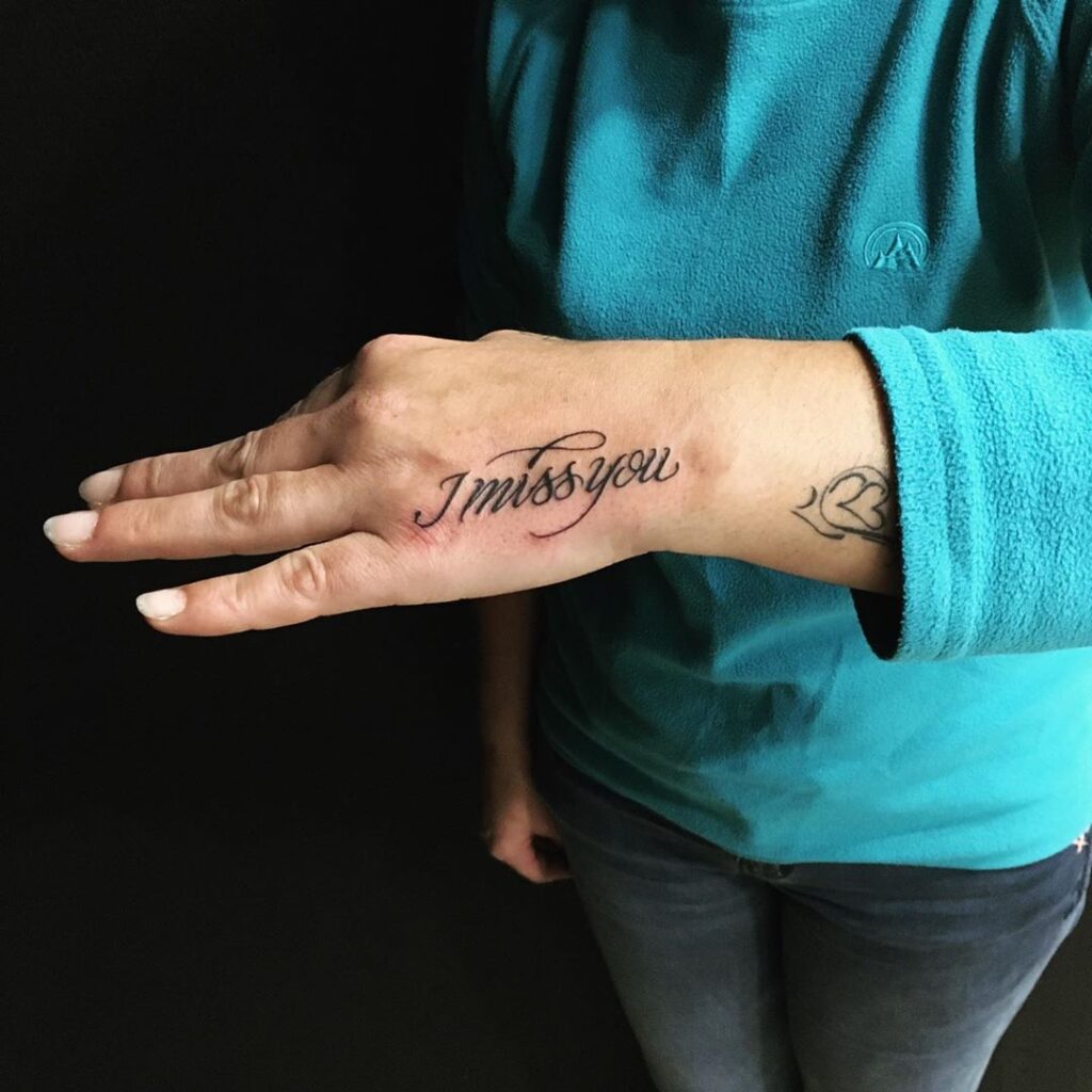 Tatouage calligraphique 'I miss you' avec une élégante écriture cursive