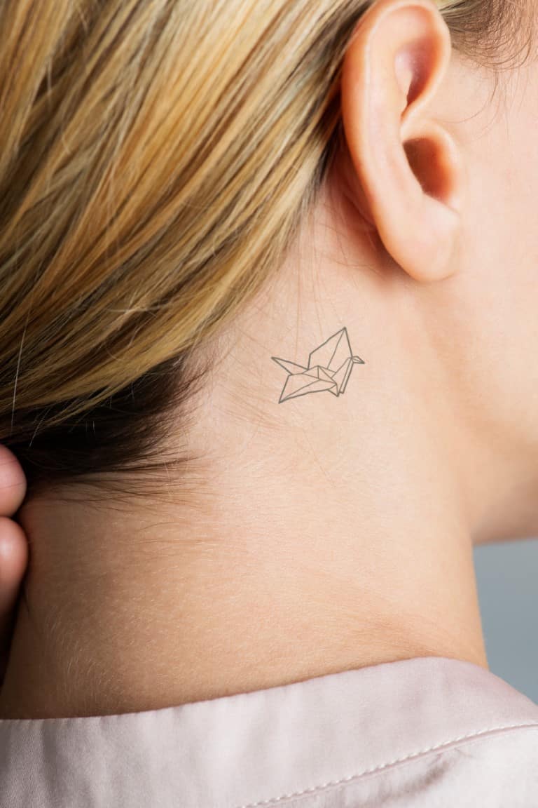 Tatouage délicat derrière l'oreille avec signification symbolique