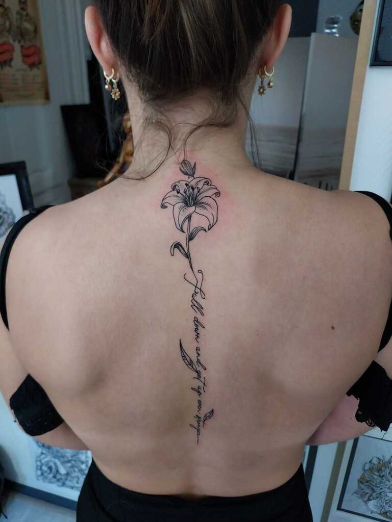 Tatouage artistique de fleur de lys en noir et gris sur l'avant-bras