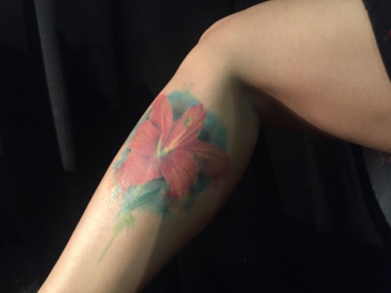 Tatouage féminin détaillé sur la jambe avec motifs floraux et élégants
