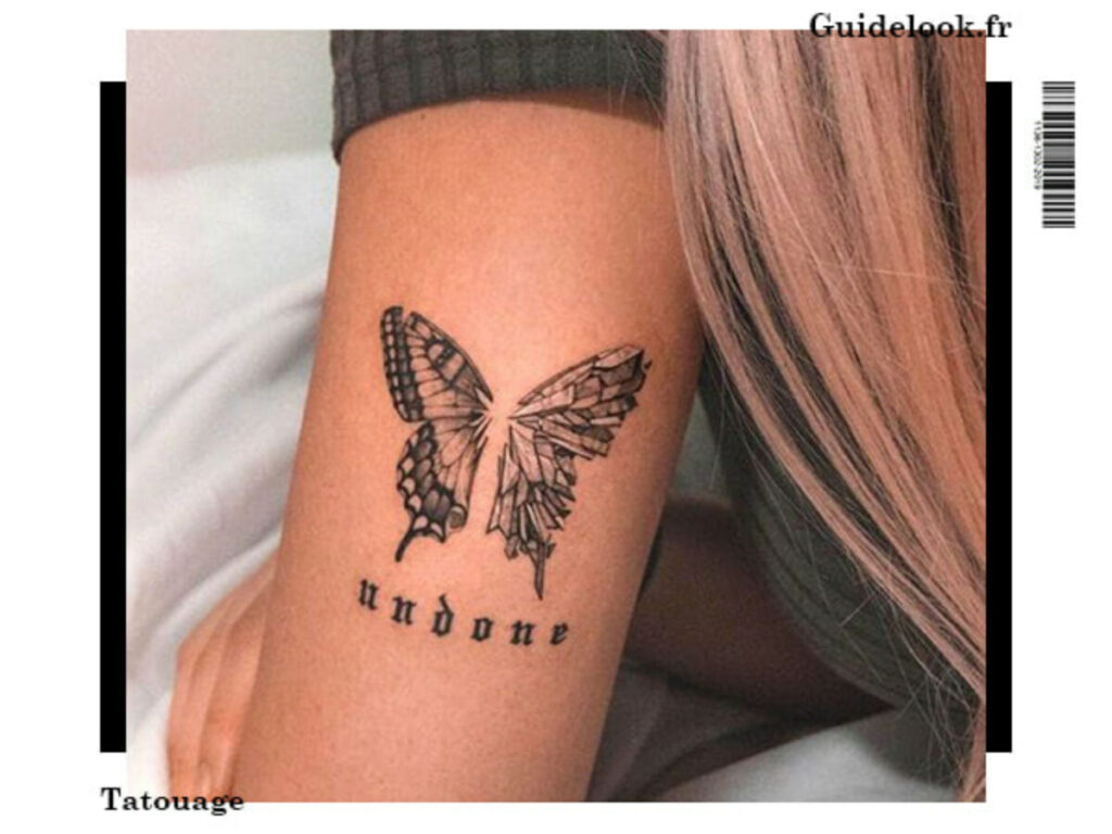 Tatouage papillon élégant sur l'avant-bras d'une femme symbolisant la transformation et la liberté.