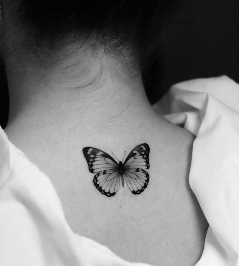 Tatouage papillon détaillé en noir et gris symbolisant la transformation et la liberté.
