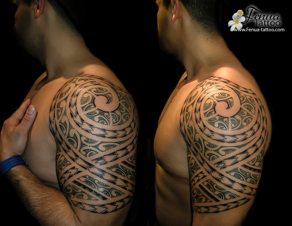 Tatouage tribal polynésien sur l'épaule et le bras, représentant des motifs traditionnels et symboliques.